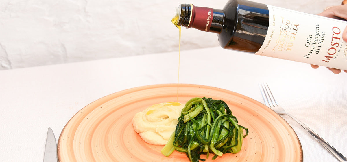 Olio extravergine di oliva Mosto Lucarella versato su fave e cicorie
